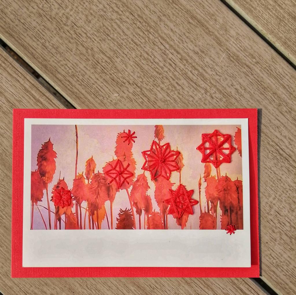 Greetings Card - Stitched Postcard. Postcard showing painting of red flowers that has been stitched into with embroidery thread. Mounted on red card